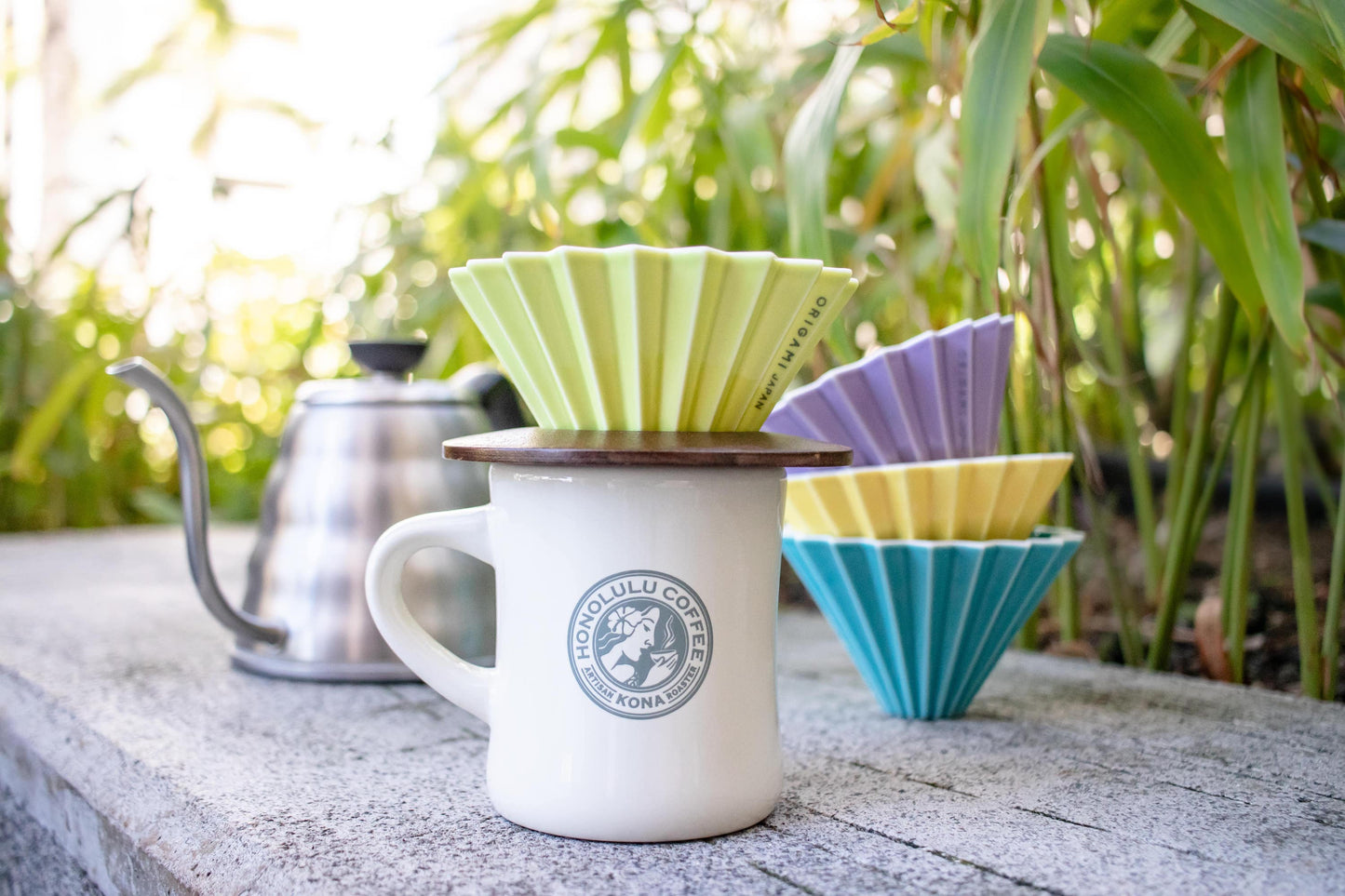 Four Origami Drippers with a Honolulu Coffee mug, wooden holder, and hot water kettle.