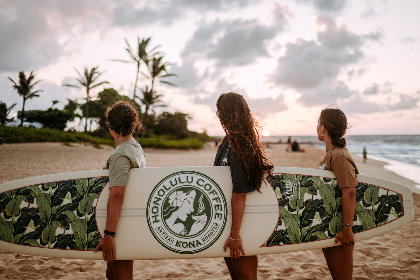 Holding our custom surfboard on the beach