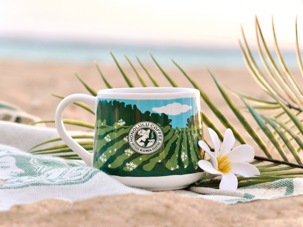 A mug with a flower on a beach towel.