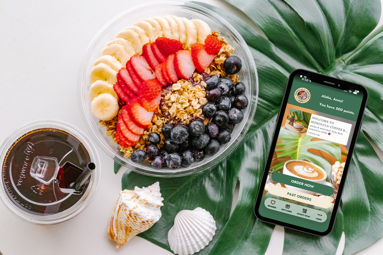 flat lay of an acai bowl, a drink, and a mobil phone